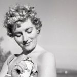 mustavalkokuvassa nainen laittaa deodoranttia